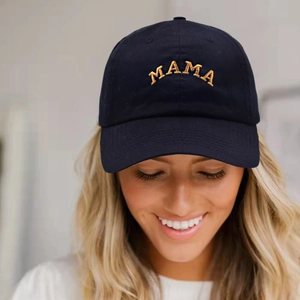 Gros plan sur la broderie MAMA dorée d'une casquette de baseball noire en coton