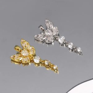 Macro detail of gold and silver butterfly pendants with dangling cubic zirconia stones