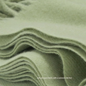 Close-up of thick light green scarf with fringe showing soft cashmere texture