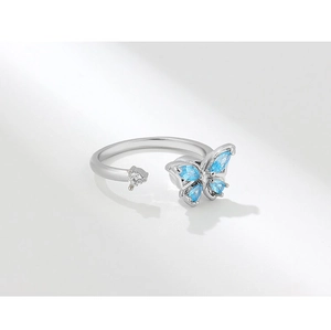 Macro detail of silver butterfly ring featuring blue and clear cubic zirconia crystals
