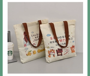 Close-up of off-white canvas bags featuring brown straps and cute animal cartoon prints