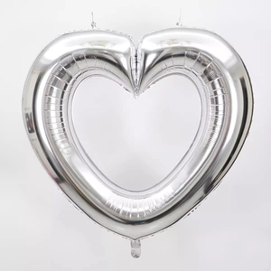 Macro detail of silver hollow heart-shaped foil balloon showing metallic texture and finish