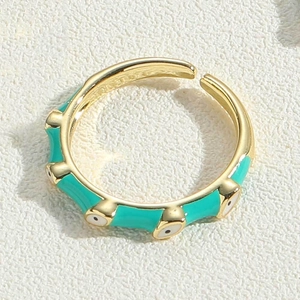 Macro view of gold evil eye open ring featuring turquoise enamel and adjustable band