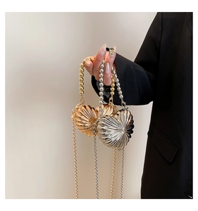 Detail of heart-shaped metal evening bags in gold and silver with beaded chain handles