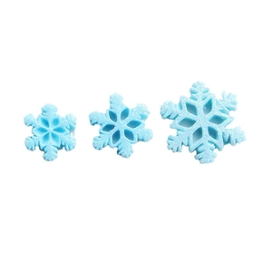 Three light blue glitter snowflake resin charms for DIY Christmas crafts on white background