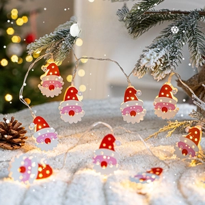 Christmas LED string lights with wooden Santa Claus pendants hanging on snowy tree