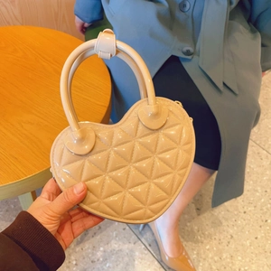 Macro shot of apricot heart-shaped jelly bag featuring quilted lattice pattern and round handle