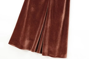 Detail of brown velvet midi dress showing the draped hemline and elegant side slit
