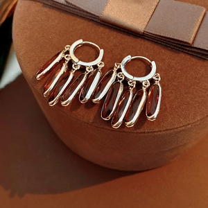Détails de boucles d'oreilles vintage en or avec pendentifs en verre ambré sur velours
