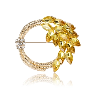 Elegant gold wheat ear round brooch with yellow and white crystals on white background