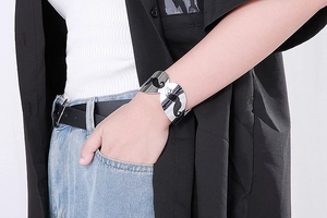 Detail of silver and black stainless steel cuff bracelet featuring a mustache design