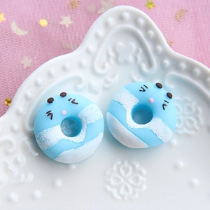 Macro view of blue and white resin donut charm with cute animal face for DIY crafts