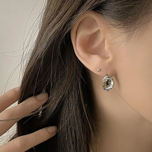 Macro shot of 925 silver irregular organic texture earrings worn by a model