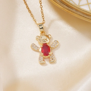 Golden teddy bear pendant necklace with red oval gemstone and pavé crystal accents