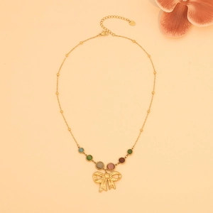 Detail of gold bow pendant necklace featuring colorful beads and refined metal chain