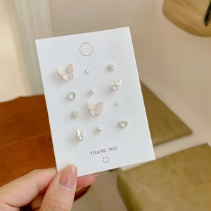 Elegant butterfly and pearl stud earring set with zirconia details on a display card