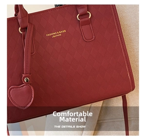 Close-up of wine red quilted faux leather handbag featuring golden metal heart charm