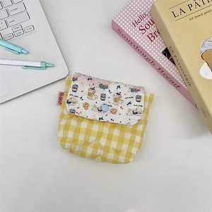 Close-up of quilted yellow plaid mini storage pouch with cute puppy print and blue snap button