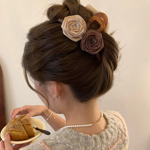 Detail der Haarklammer aus Organza mit Perlen auf beigen und braunen Stoffrosen