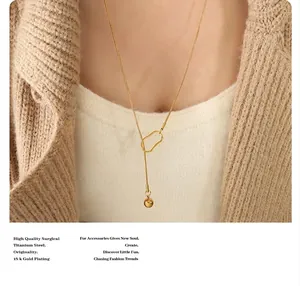 Close-up of 18k gold plated titanium steel sweater chain with sphere pendant on a model