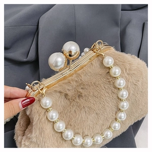 Close-up of khaki faux fur clutch with oversized white pearl clasp and gold handle