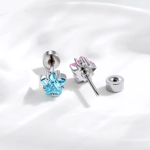 Minimalist silver star earrings with blue and pink cubic zirconia on white fabric