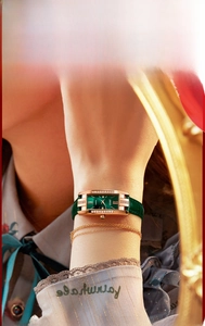 Detailed macro view of a vintage rectangular watch with green dial and gold case