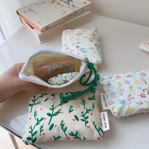 Close-up of floral cotton pouch showing zipper detail and small item storage