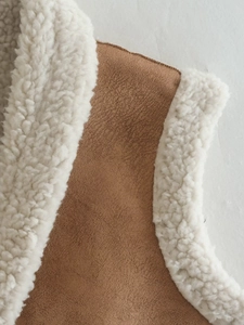 Detail of brown faux suede fabric with white sherpa lining texture and seam stitching