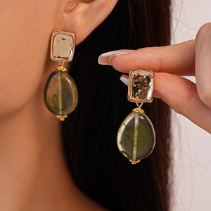 Metallic gold textured earrings with irregular translucent green resin teardrop charms