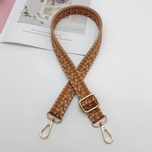Close-up of geometric woven replacement shoulder strap with gold metal buckles