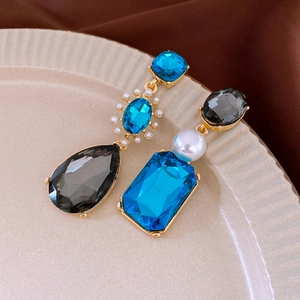 Détail macro de boucles d'oreilles vintage asymétriques avec cristaux et perles