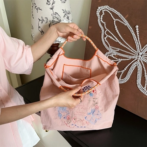 Détail du sac cabas rose brodé avec motifs floraux et poche intérieure