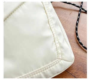Detailed macro view of white nylon bag with double-stitching and black-white drawstring