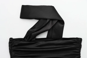Detailed macro view of black satin fabric with elegant pleated wrap neckline design