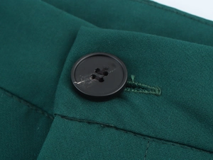 Macro shot of dark green woven fabric texture with a classic black four-hole button detail