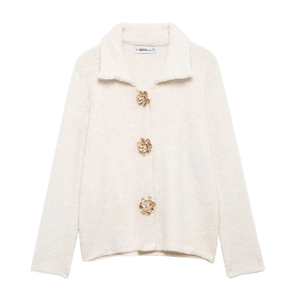 Dettaglio di cardigan in ecopelliccia crema con bottoni metallici a forma di fiore