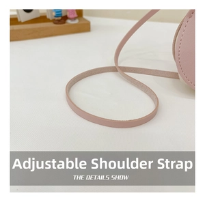Detail showing the adjustable shoulder strap with fine stitching on a pink rabbit bag