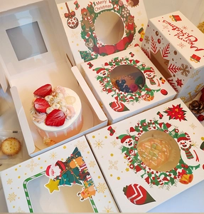 Close-up of festive Christmas cupcake boxes with clear windows and Santa Claus patterns