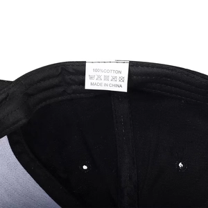 Detailed view of 100% cotton stitching and washing label inside the black baseball cap