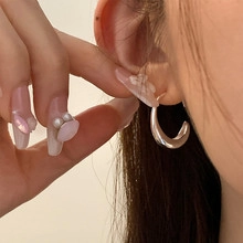 Close-up of polished silver hoop earrings worn to show the elegant French vintage style