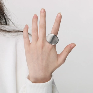Close-up of a vintage brushed silver stainless steel oval ring worn on a finger
