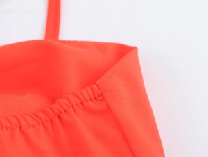Close-up of red embroidery details and shoulder strap texture on a summer vacation dress