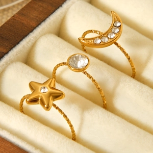 Detailed view of three gold star and moon rings set with zircons in a jewelry box