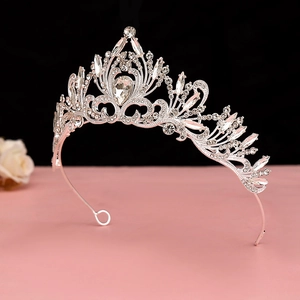 Detailed view of silver baroque tiara with pear-shaped center crystal and intricate rhinestones