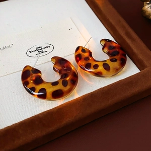 Close-up of leopard pattern C-shaped resin earrings with a vintage tortoiseshell finish