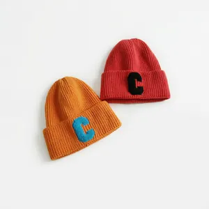 Orange and red ribbed knit beanies with plush letter C patches in a stylish set