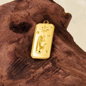 Détail d'un pendentif soleil et lune en or 18 carats sur une surface en bois rustique