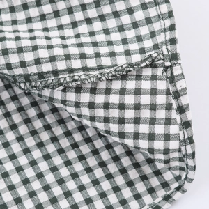 Macro shot of green and white plaid fabric texture with precise stitching detail