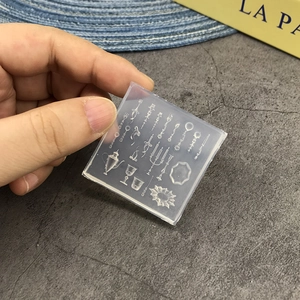 Handheld view of a transparent silicone mold with miniature tableware and candle patterns